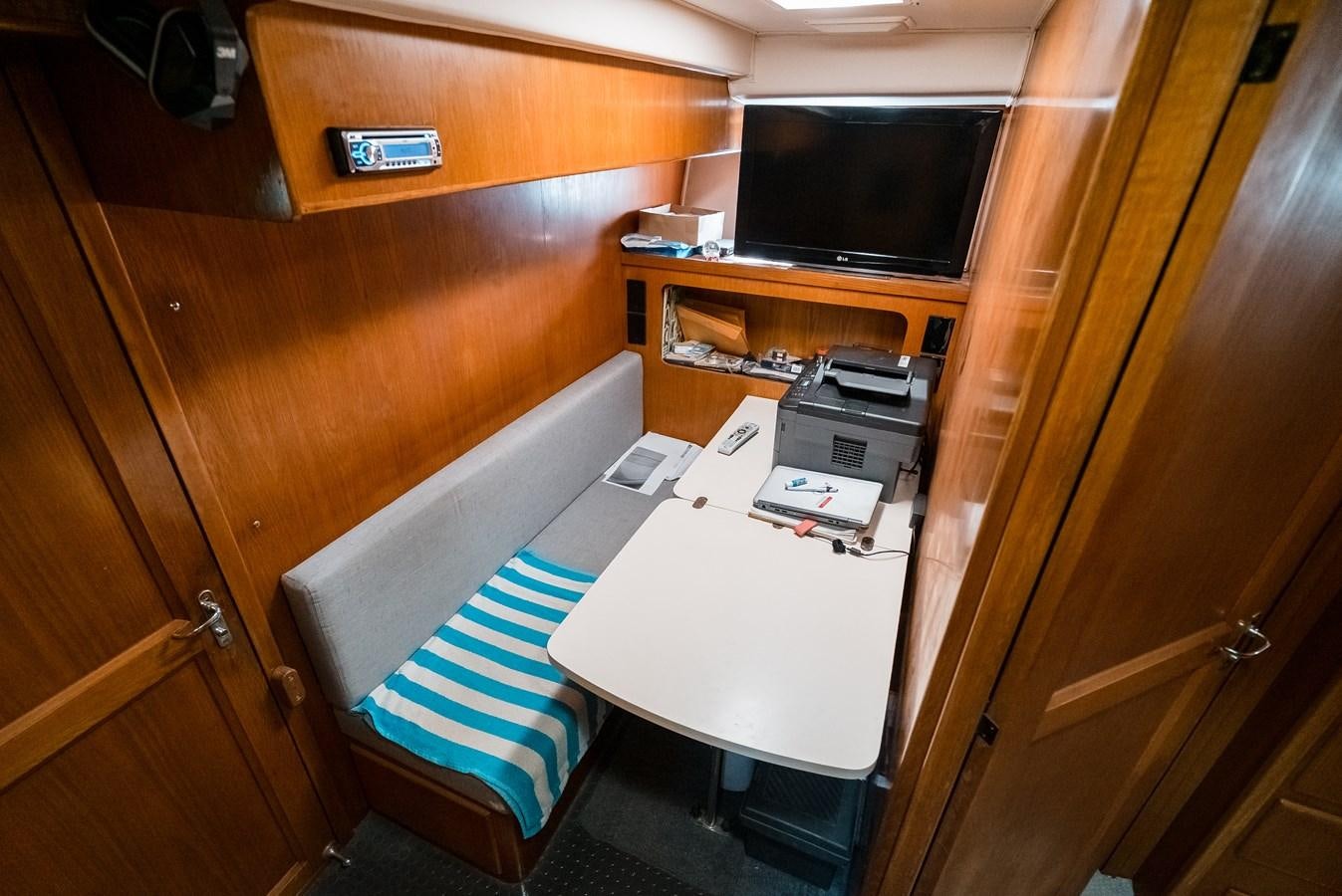 a room with a table and a tv aboard HIGH IMPACT Yacht for Sale