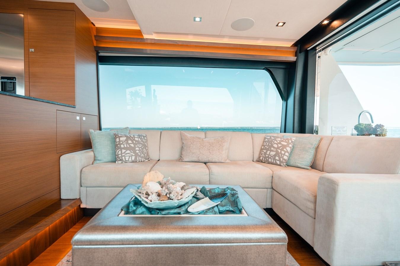 a couch with a table and a window aboard THE THREE B'S Yacht for Sale