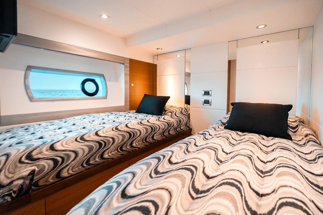 a bedroom with a bed and a tv on the wall aboard THE THREE B'S Yacht for Sale