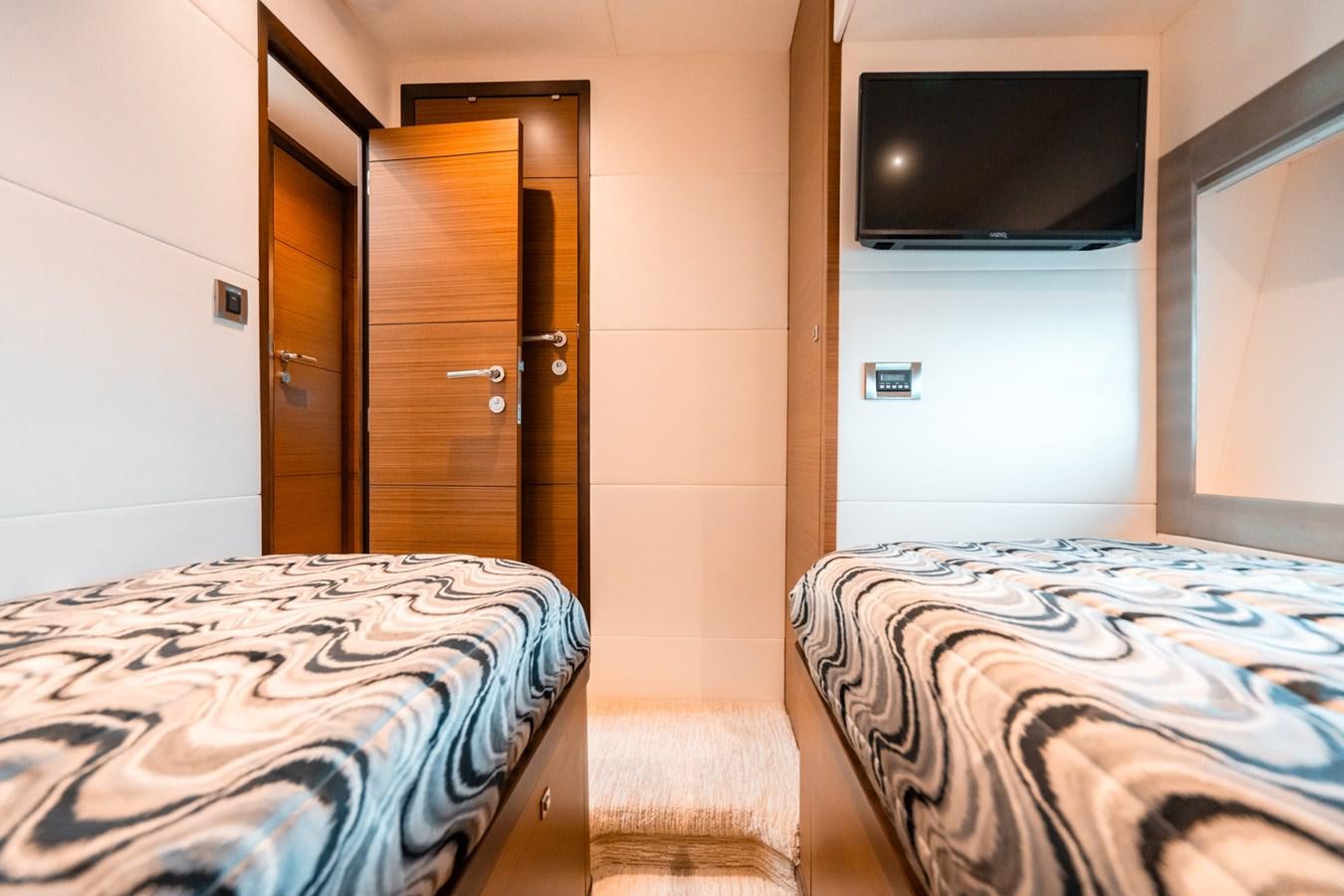 a room with a bed and a television aboard THE THREE B'S Yacht for Sale