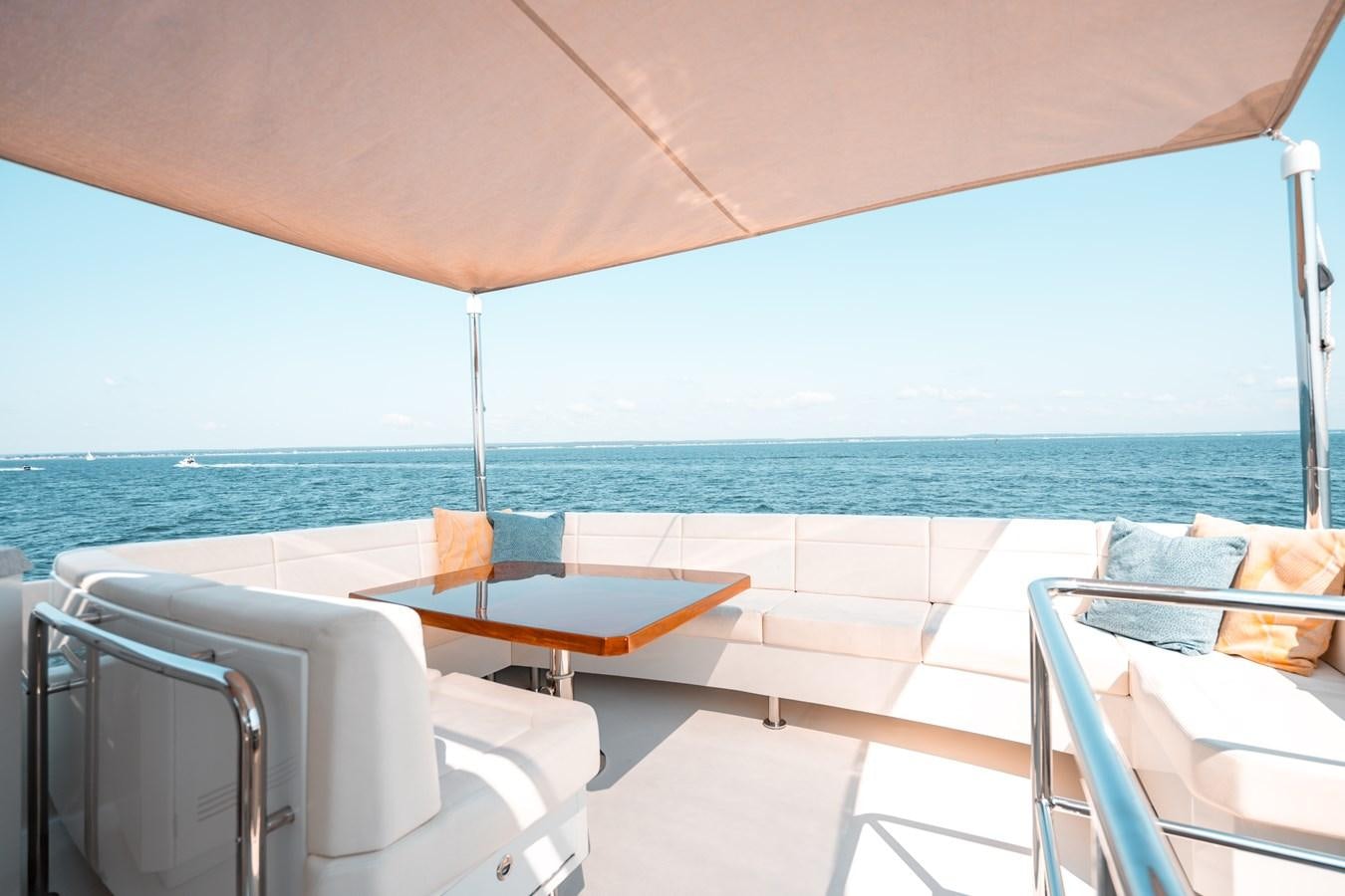 a white umbrella over a table and chairs on a deck aboard THE THREE B'S Yacht for Sale
