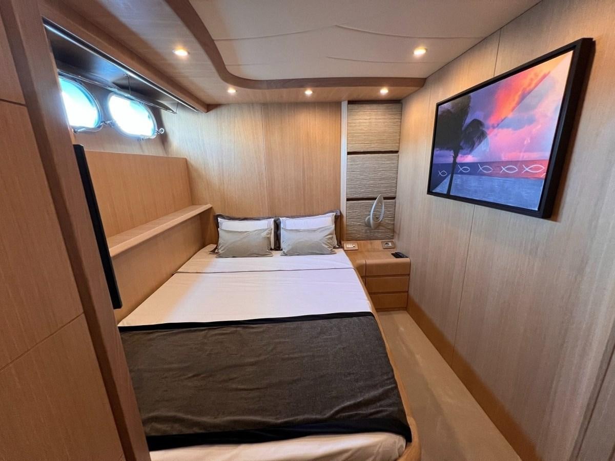 a room with a bed and a television on the wall aboard MAIORA 26 Yacht for Sale