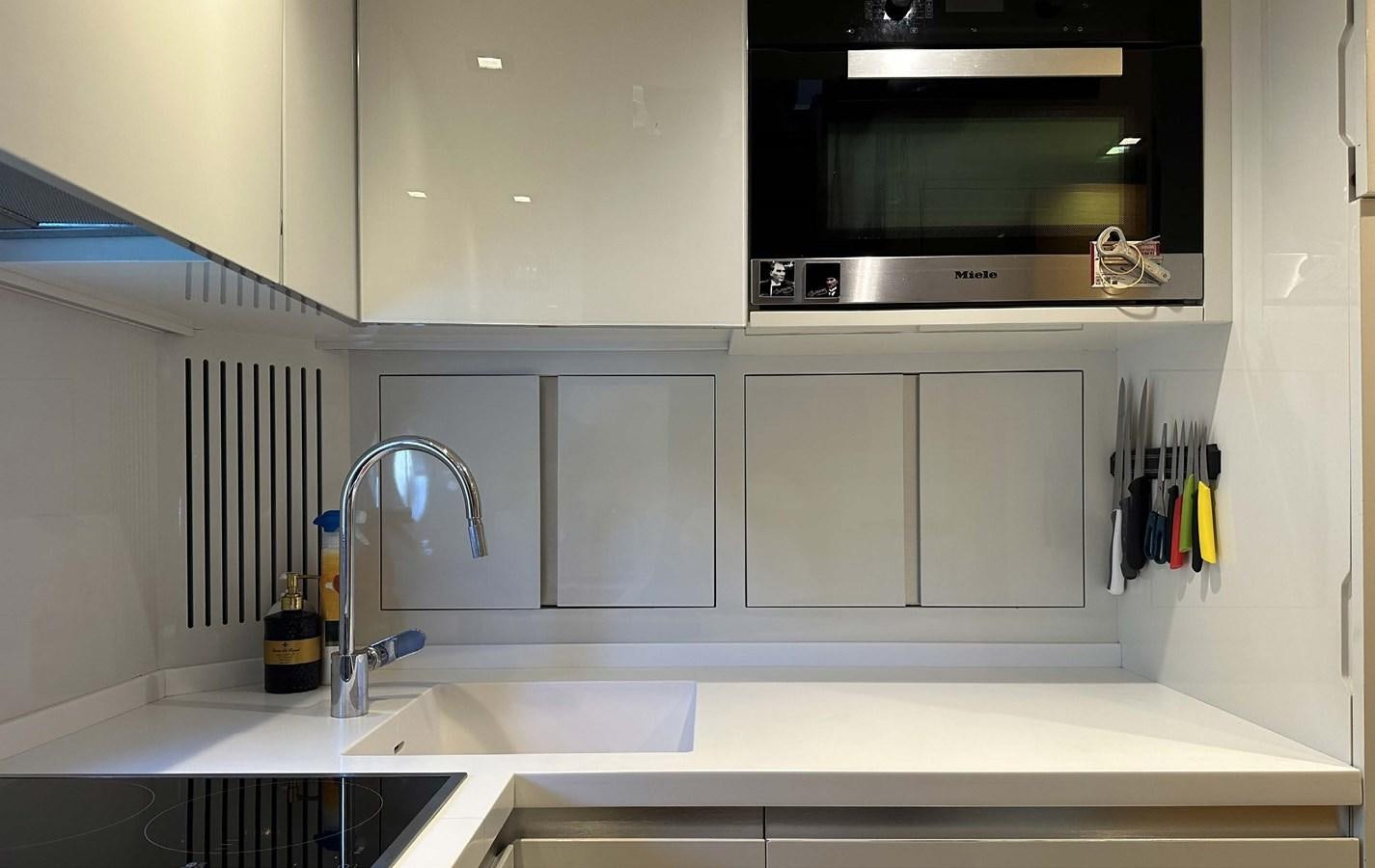 a kitchen with white cabinets aboard TYCHE Yacht for Sale