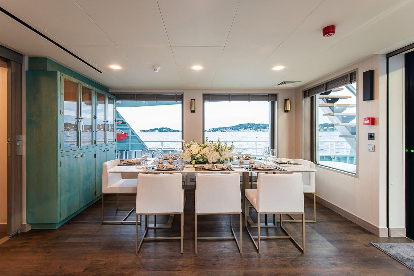 a table and chairs in a room aboard FIVE OCEANS Yacht for Sale
