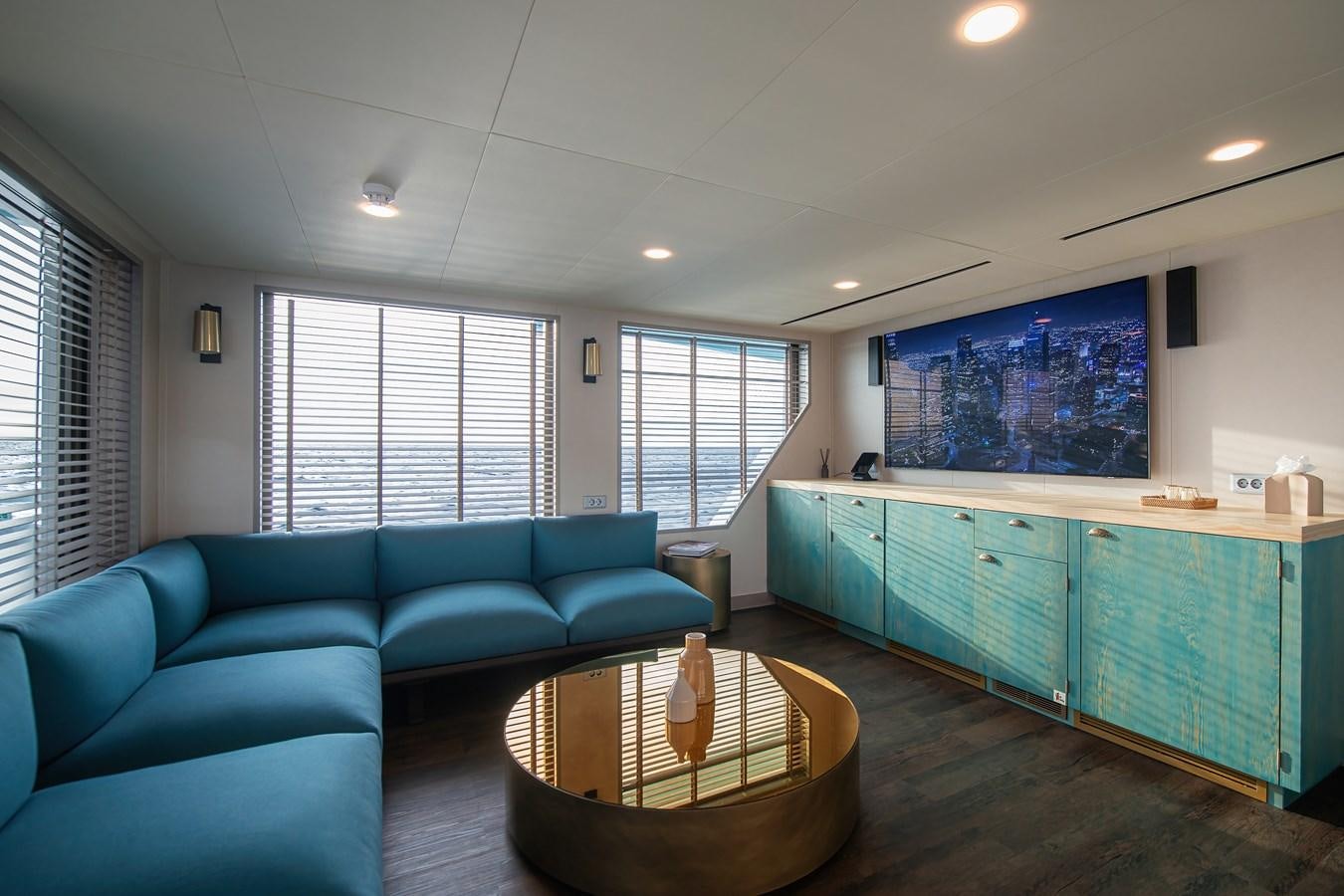 a living room with a blue couch aboard FIVE OCEANS Yacht for Sale