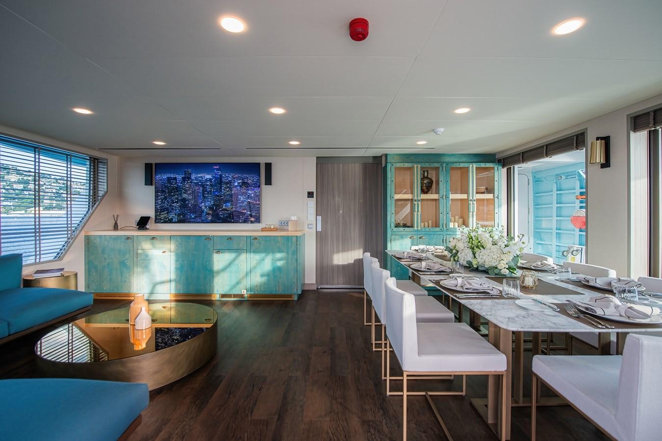 a room with tables and chairs aboard FIVE OCEANS Yacht for Sale