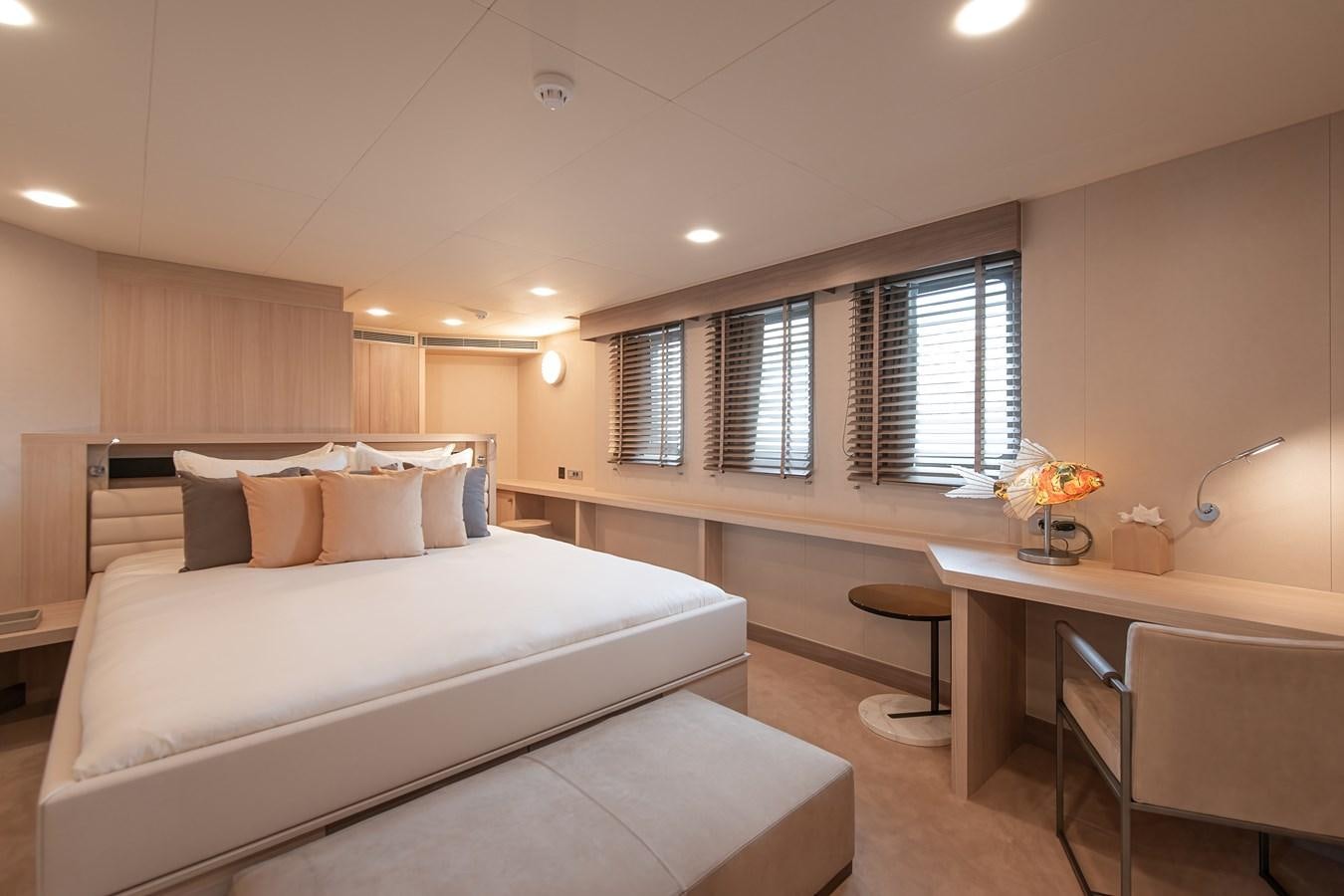 a bedroom with a bed and desk aboard FIVE OCEANS Yacht for Sale