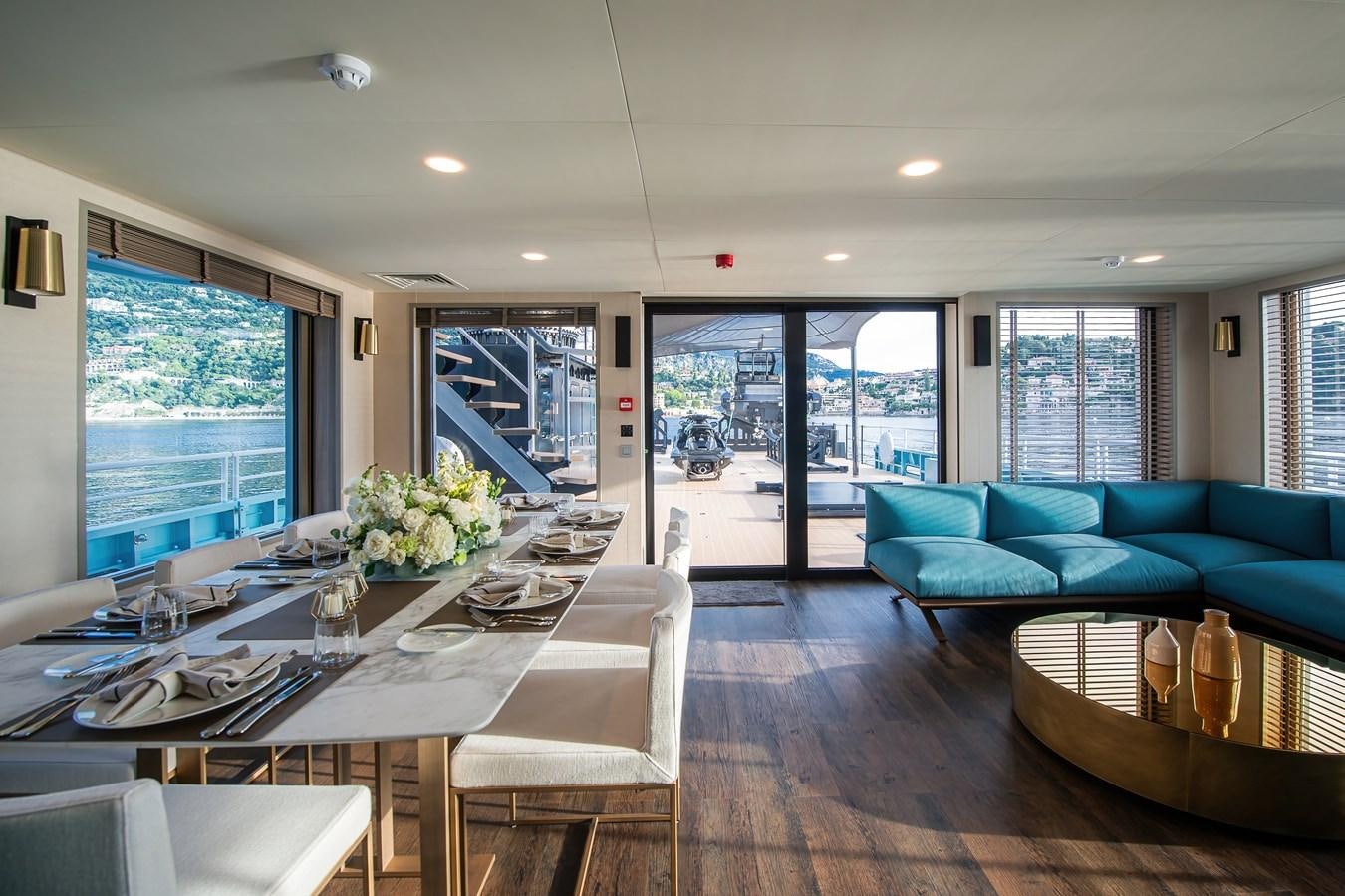 a large living room with a table and chairs aboard FIVE OCEANS Yacht for Sale
