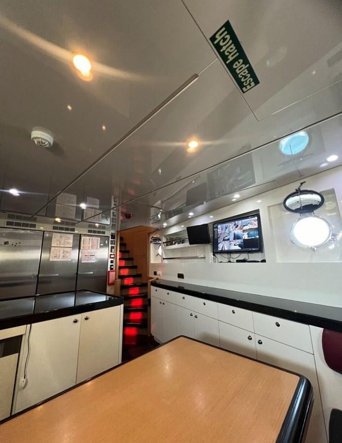 a kitchen with a counter and a tv on the wall aboard WHISPER Yacht for Sale