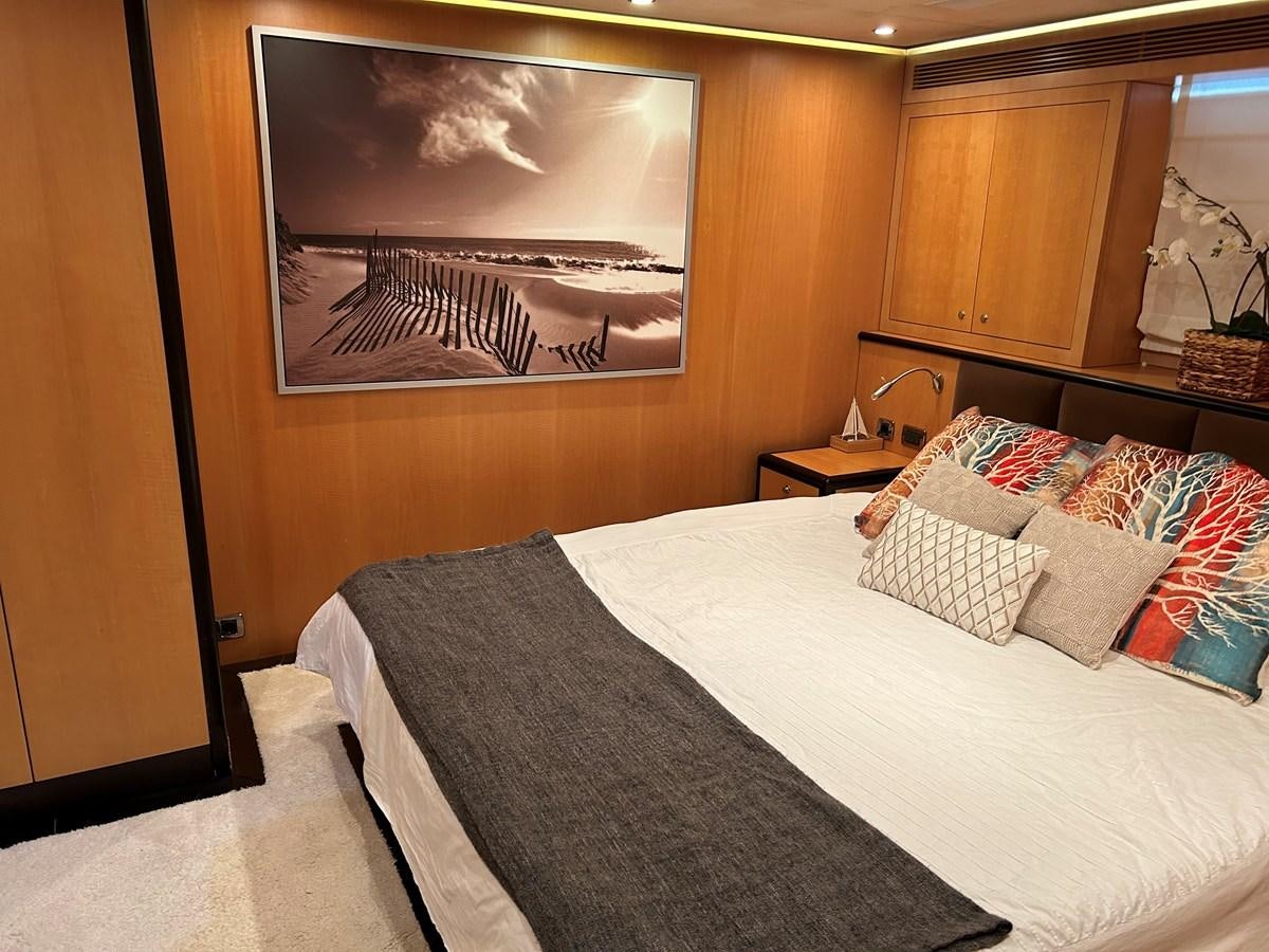 a bed with a painting on the wall aboard WHISPER Yacht for Sale