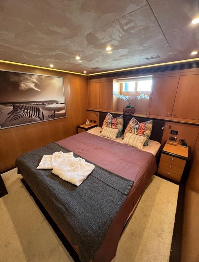 a bedroom with a bed and a chair aboard WHISPER Yacht for Sale