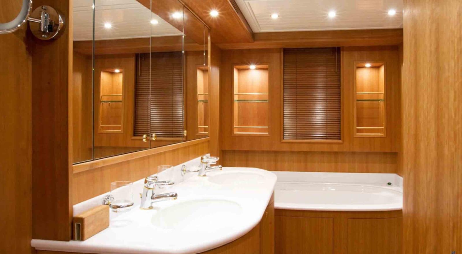 a bathroom with a tub sink and cabinets aboard COUACH 3000 FLY Yacht for Sale