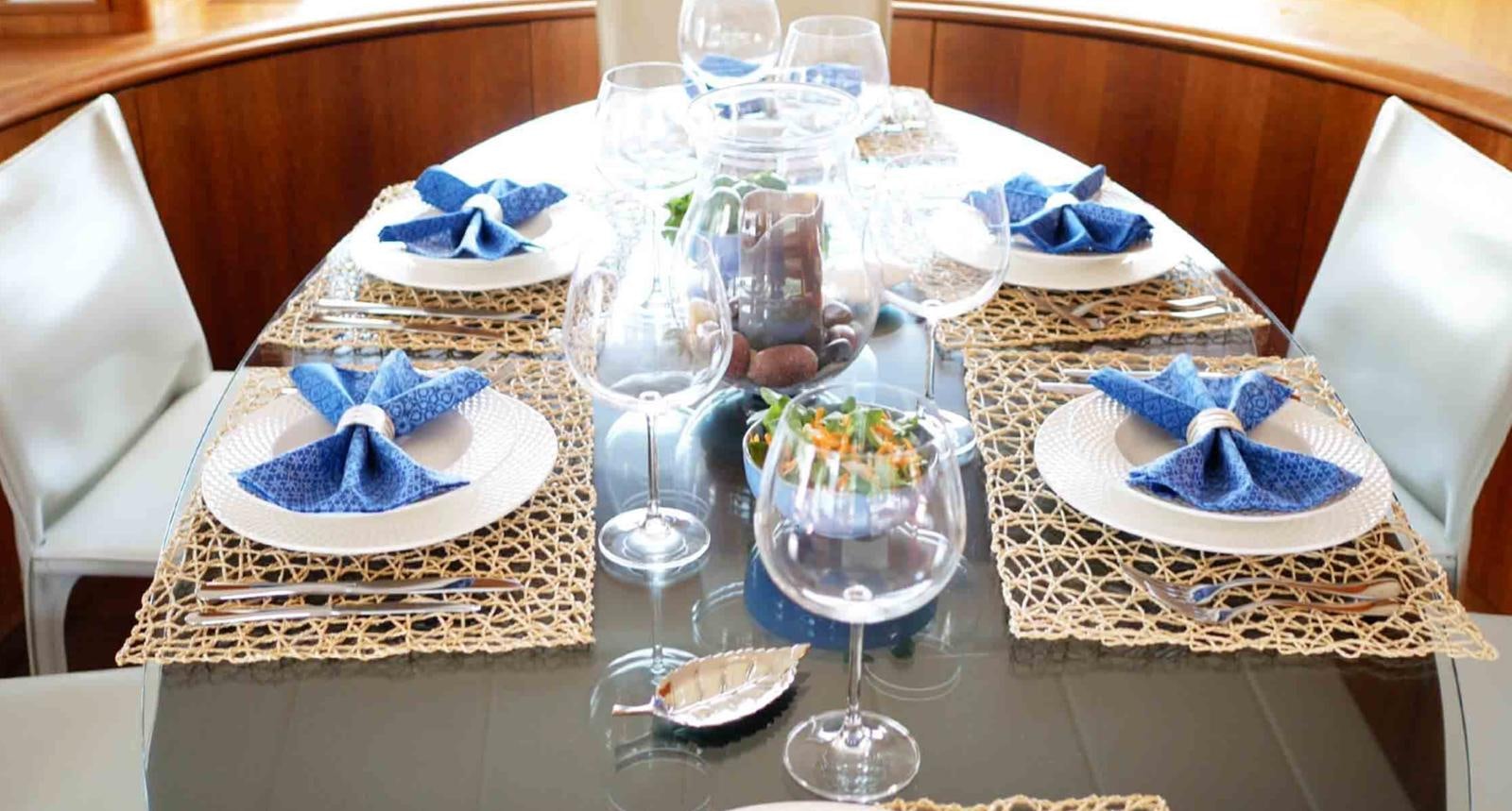 a table with a plate of food and glasses on it aboard COUACH 3000 FLY Yacht for Sale