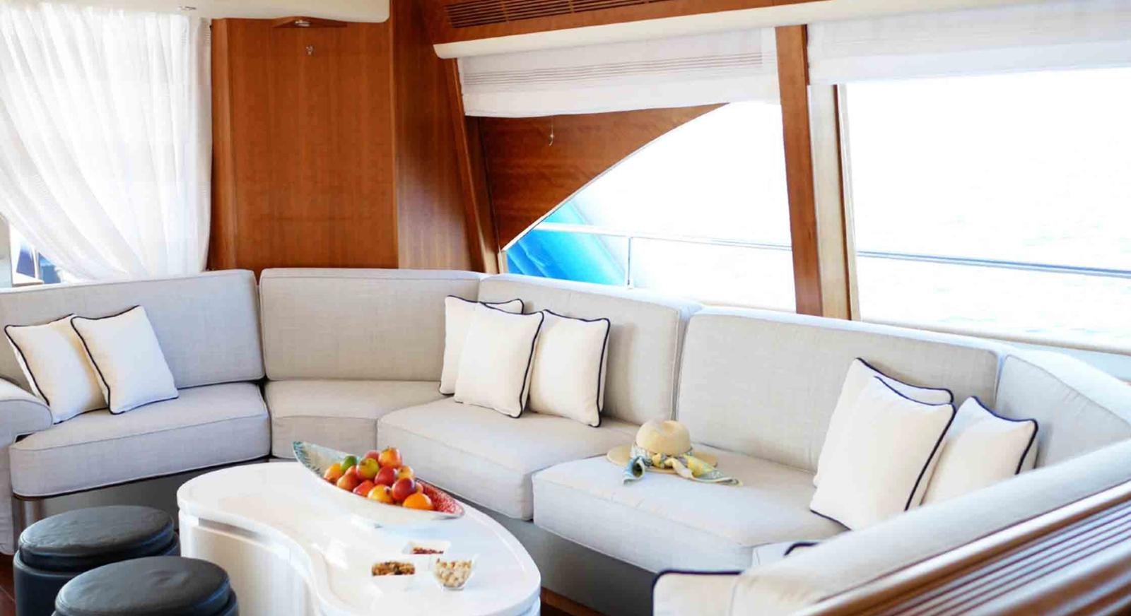 a white couch with a white table and white pillows and a white coffee table with a white pillow aboard COUACH 3000 FLY Yacht for Sale