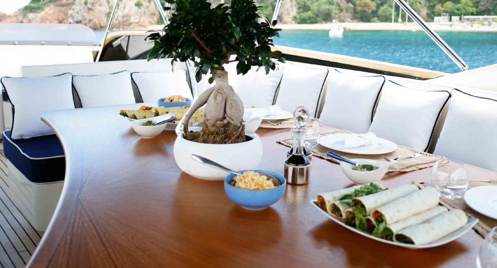 a table with plates and bowls of food on it aboard COUACH 3000 FLY Yacht for Sale