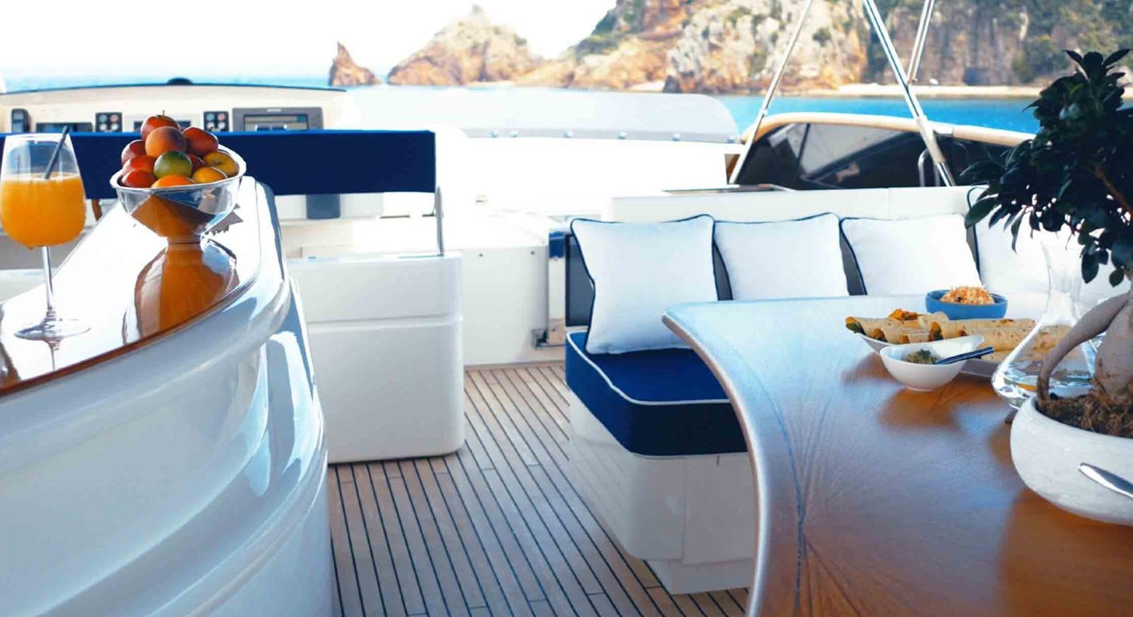a table with chairs and a glass of juice on it aboard COUACH 3000 FLY Yacht for Sale