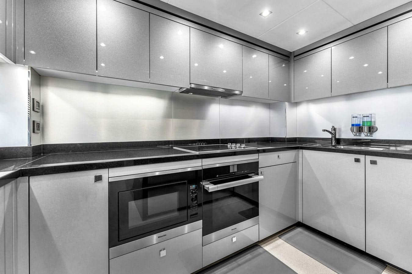 a kitchen with white cabinets aboard 2018 SUNSEEKER 95 YACHT Yacht for Sale