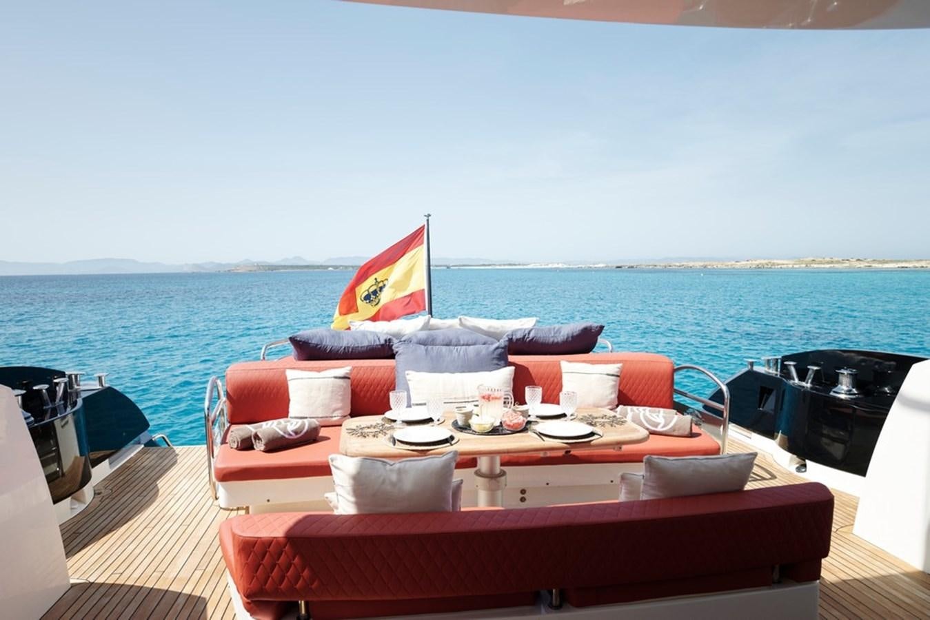 a table with chairs and umbrellas on it by the ocean aboard SUNSEEKER PREDATOR 92 Yacht for Sale