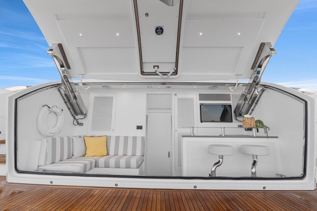 a white room with a white couch and a window aboard JEMILY II Yacht for Sale
