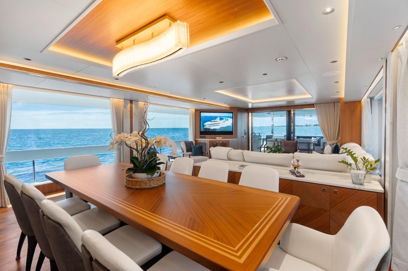 a room with a table chairs and a tv aboard JEMILY II Yacht for Sale