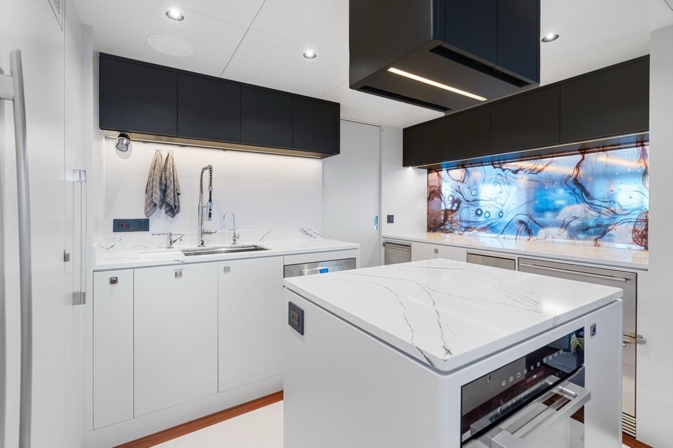 a kitchen with a large white counter aboard JEMILY II Yacht for Sale