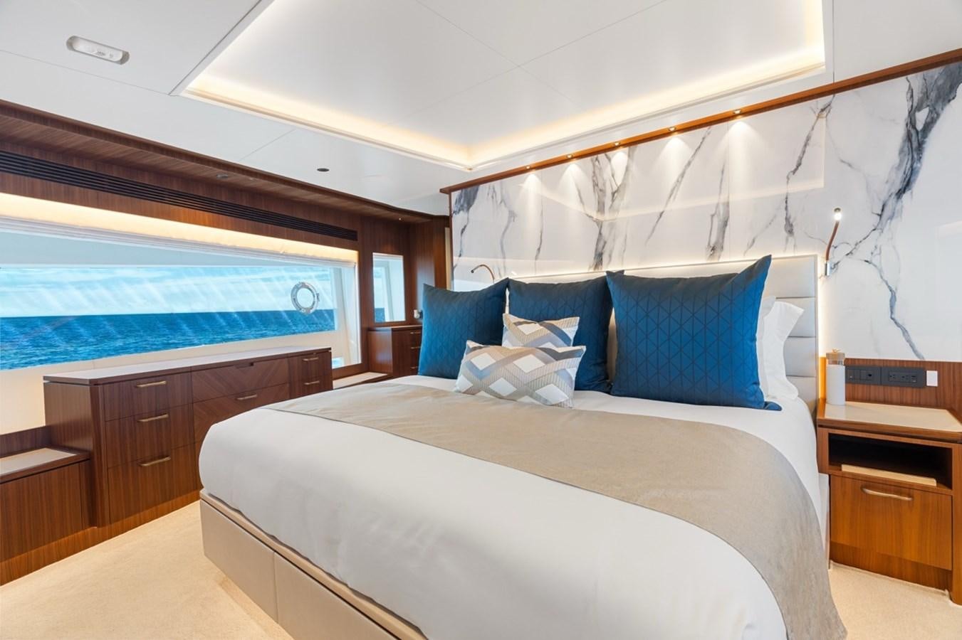 a bed with blue pillows aboard JEMILY II Yacht for Sale