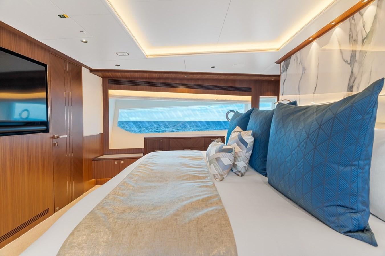 a bed with a blue pillow aboard JEMILY II Yacht for Sale