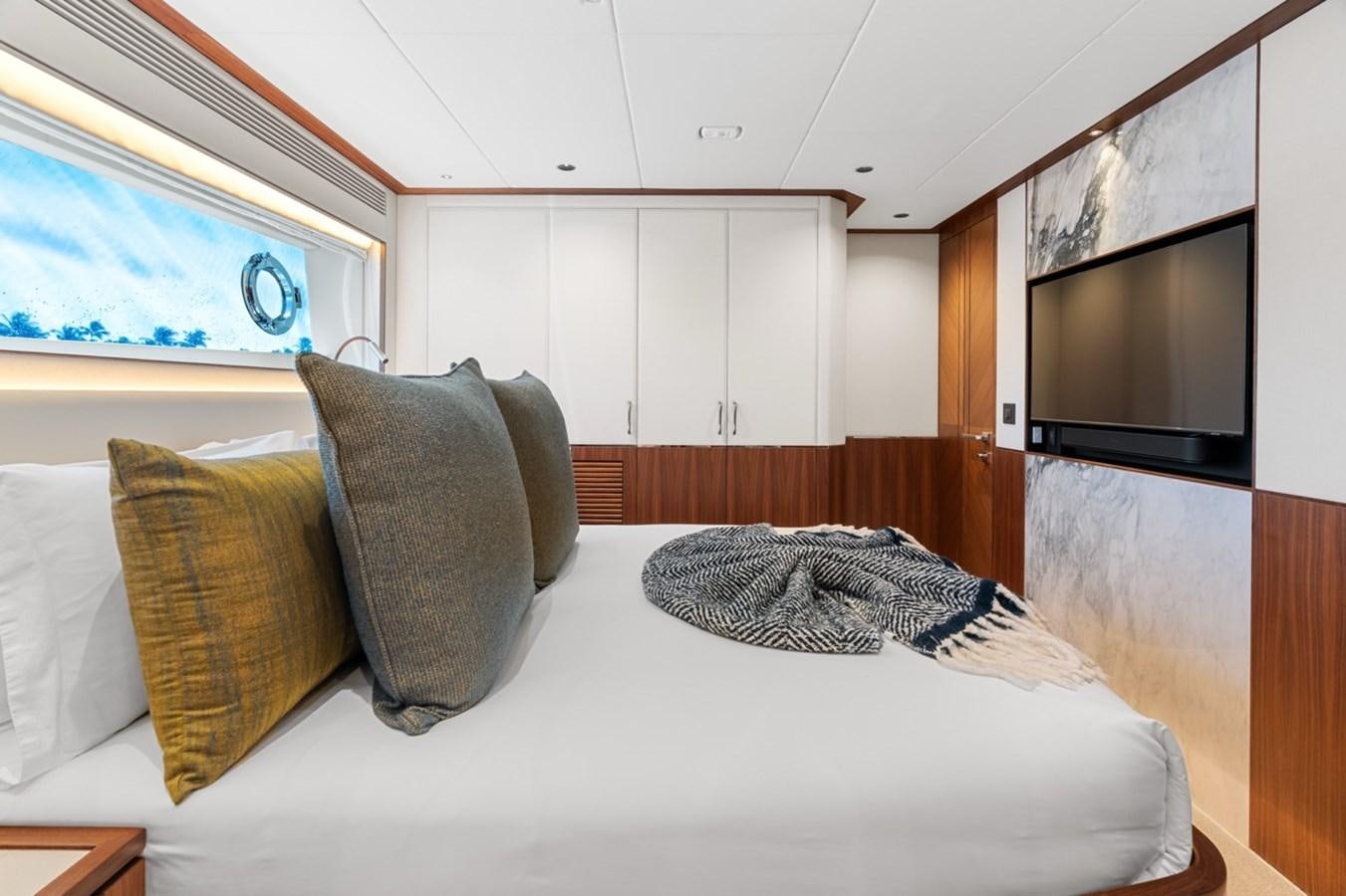 a bed with pillows and a television aboard JEMILY II Yacht for Sale