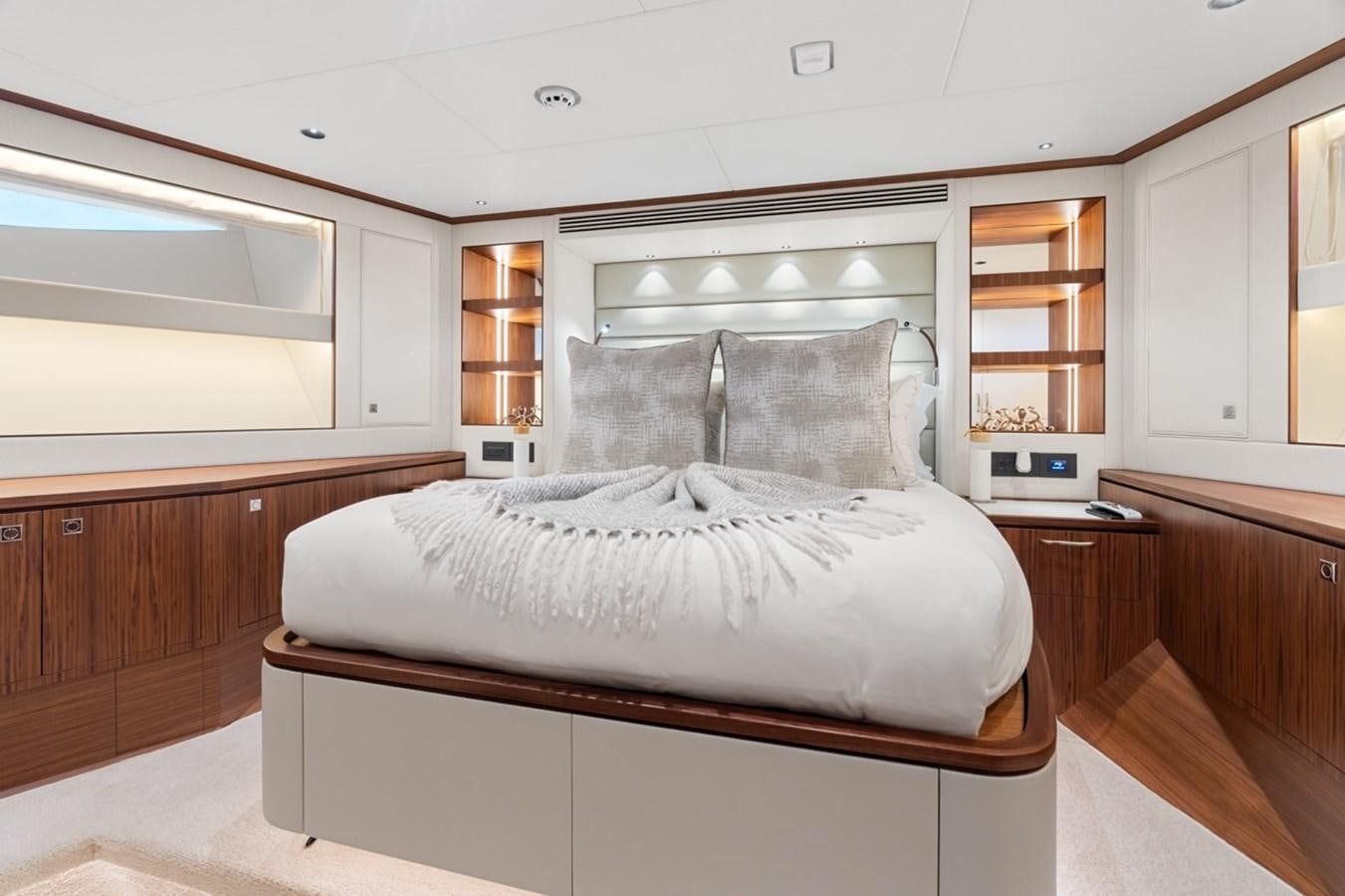 a bedroom with a bed and a bookcase aboard JEMILY II Yacht for Sale
