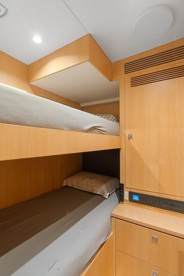 a room with a bed and a wood cabinet aboard JEMILY II Yacht for Sale