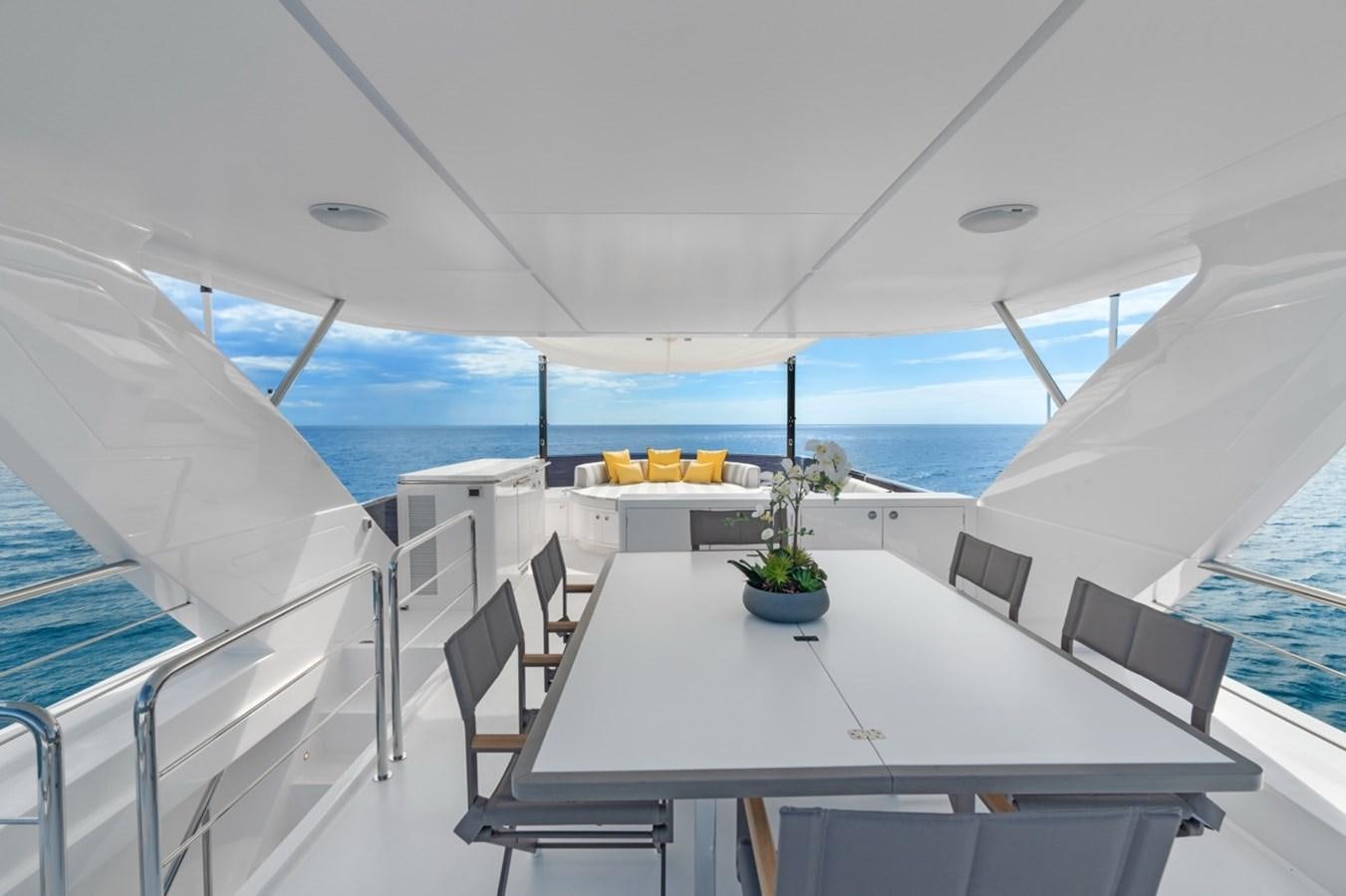 a white table with chairs and a white table with a plant on it aboard JEMILY II Yacht for Sale