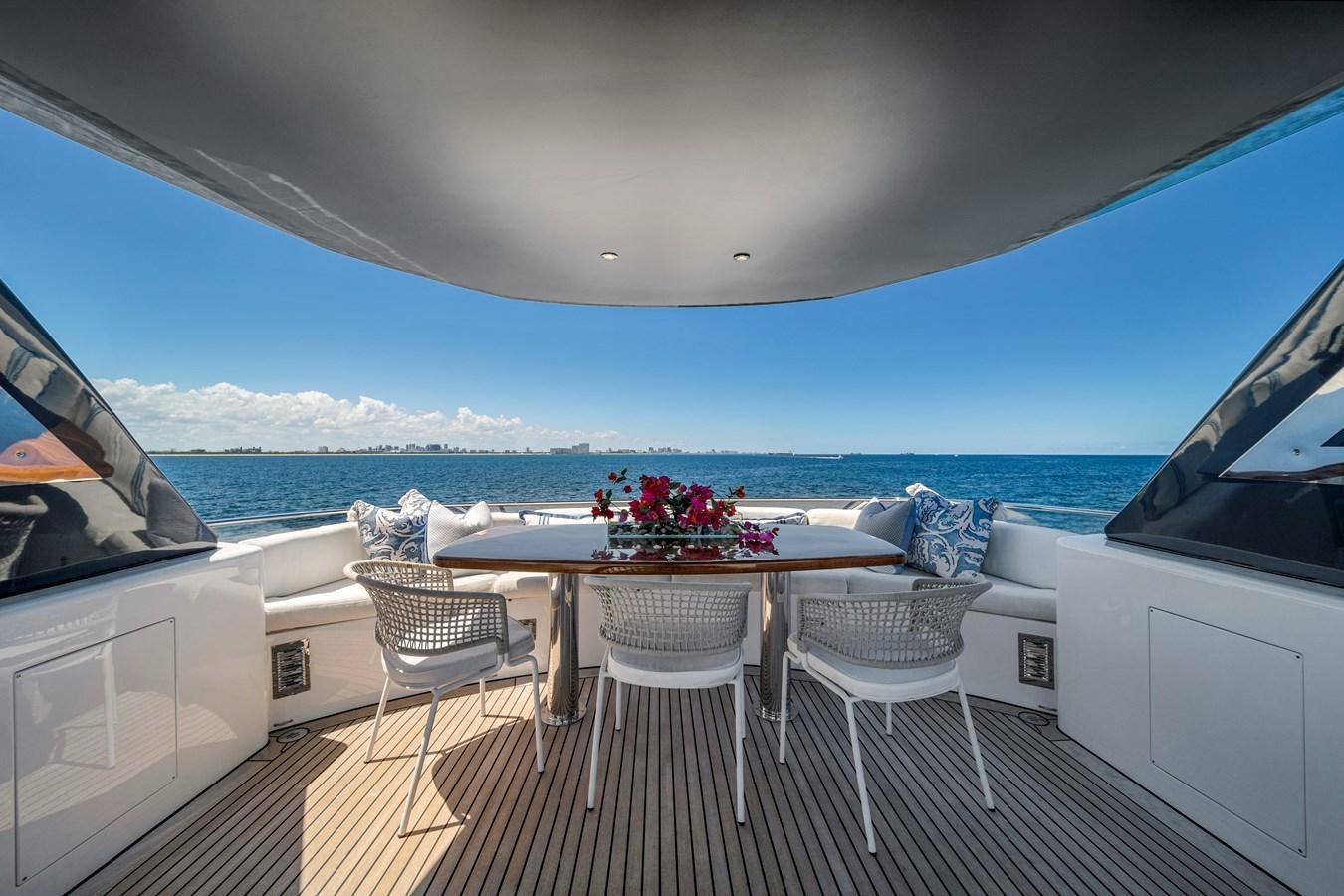 a table and chairs on a deck overlooking the ocean aboard FAMILYBILT Yacht for Sale