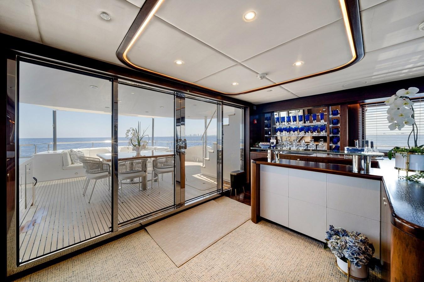 a large modern looking room with glass doors aboard FAMILYBILT Yacht for Sale