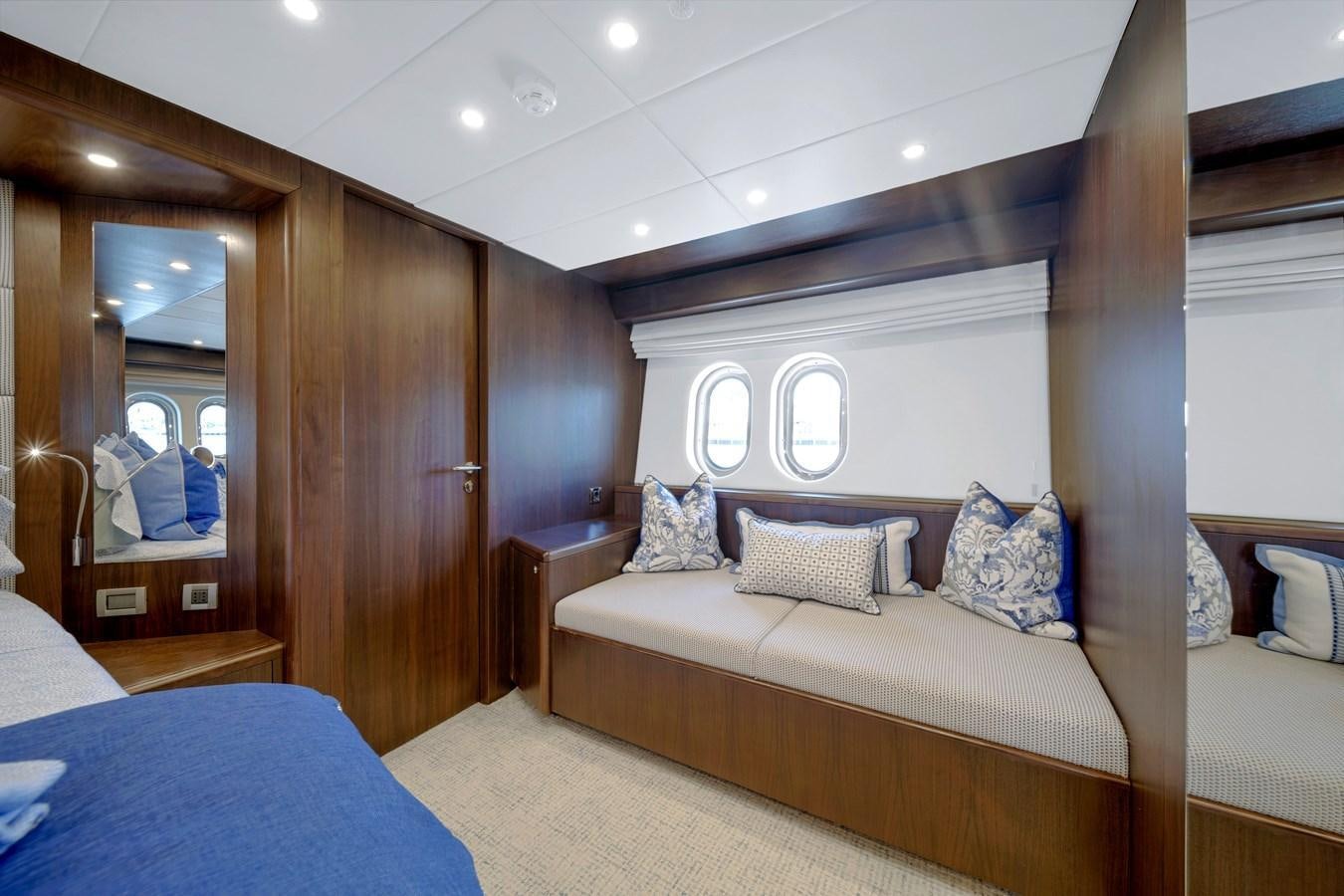 a bedroom with a bed and a mirror aboard FAMILYBILT Yacht for Sale