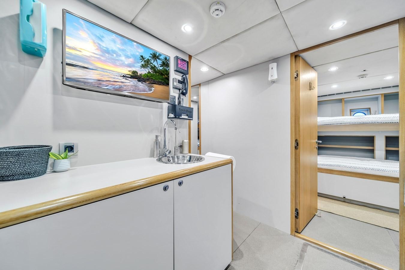 a bathroom with a countertop sink and a wood door aboard FAMILYBILT Yacht for Sale