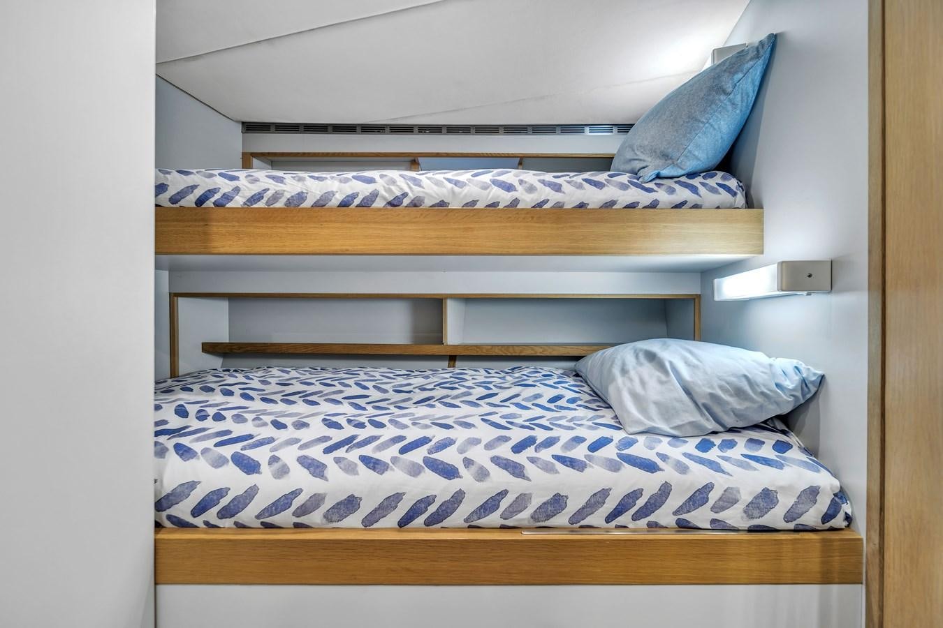 a bed with blue and white sheets aboard FAMILYBILT Yacht for Sale