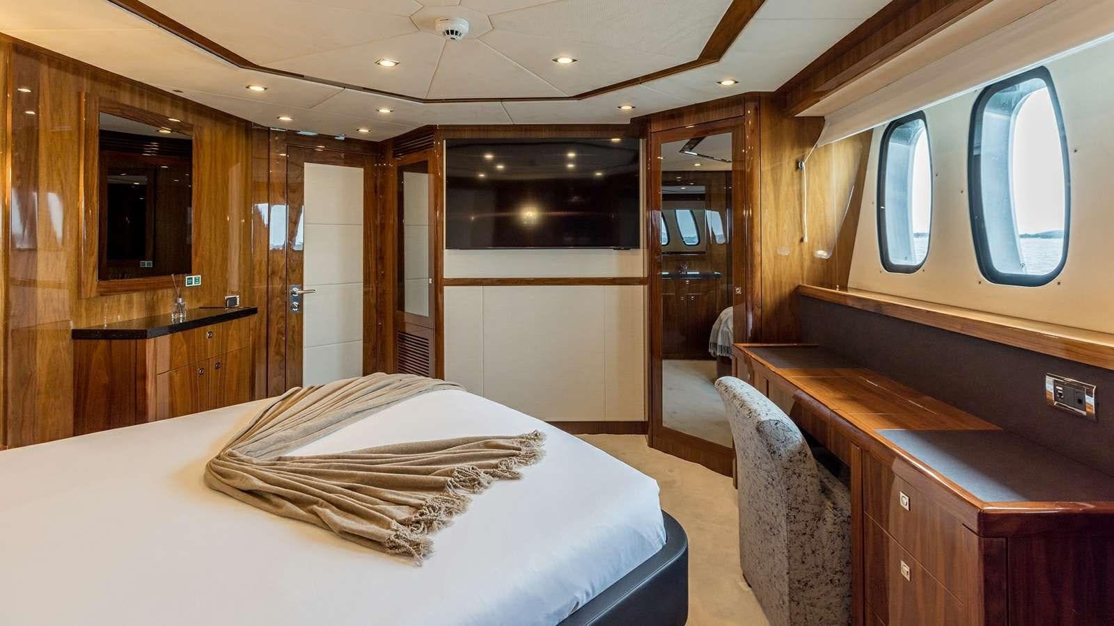 a room with a bed and desk aboard KATARIINA I Yacht for Sale