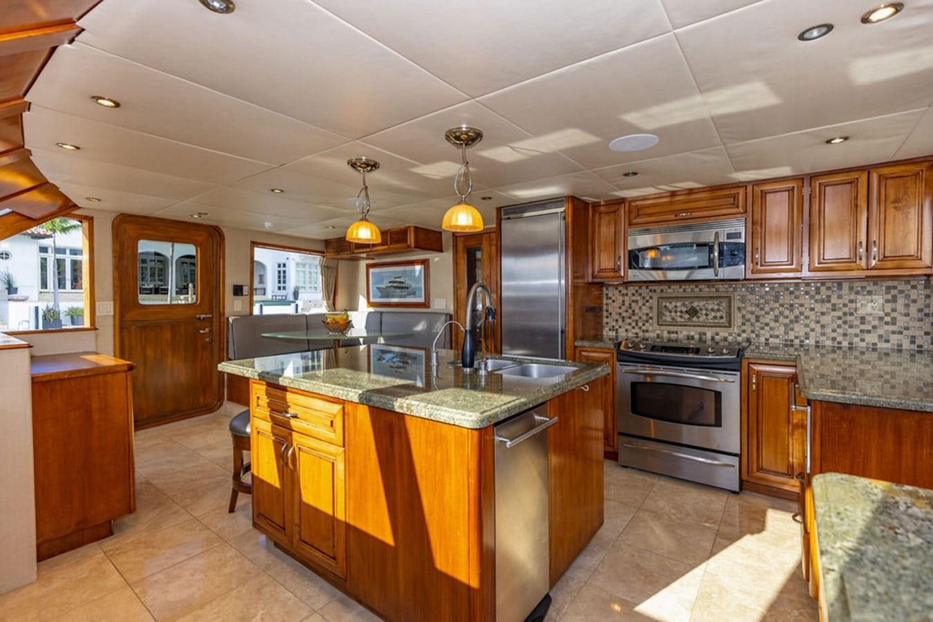 a kitchen with wooden cabinets aboard EMPIRE SEA Yacht for Sale