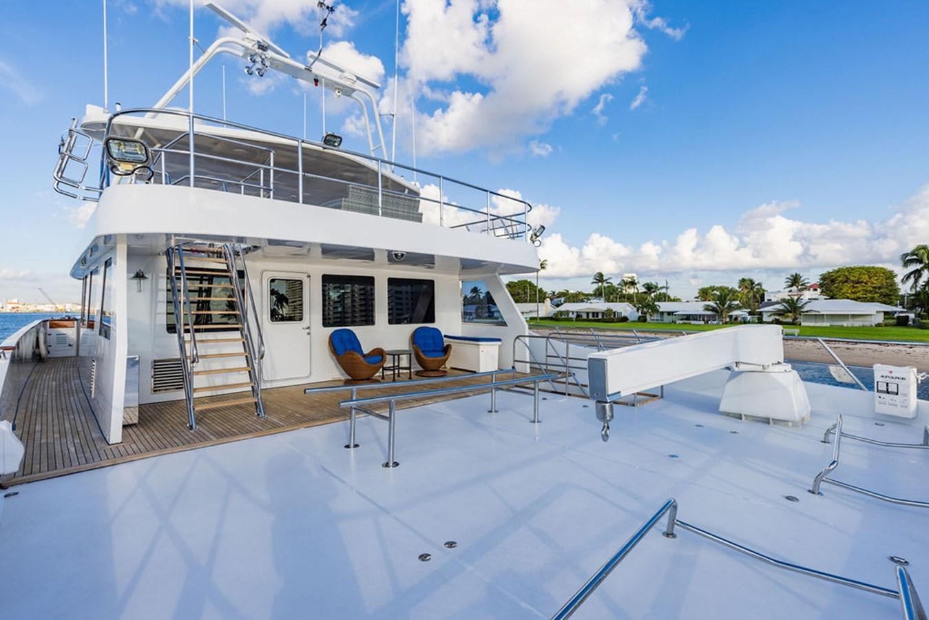 a white building with a deck and a pool aboard EMPIRE SEA Yacht for Sale