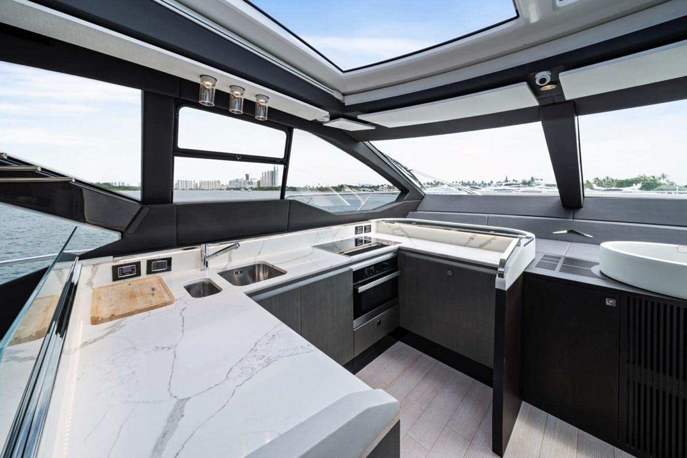 a room with a large window and a table with chairs aboard JUST KEEP LIVIN Yacht for Sale