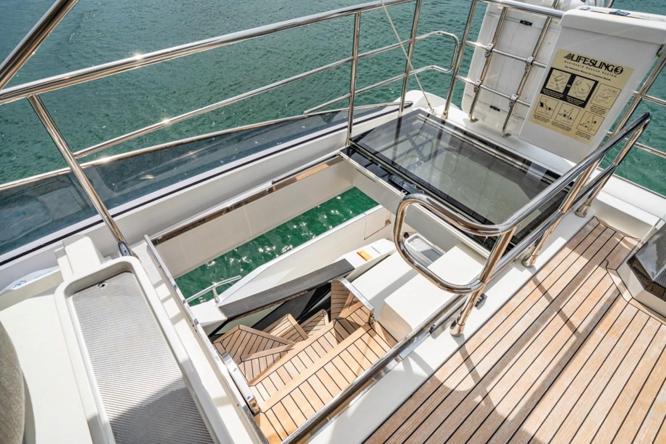a large glass window with a green screen and a wooden surface aboard JUST KEEP LIVIN Yacht for Sale