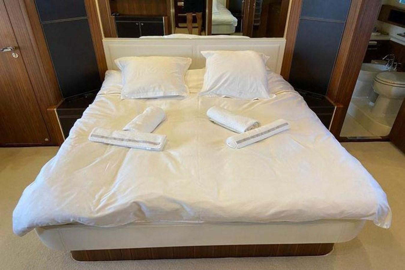 a bed with a pillow and a phone on it aboard RIVA 85 OPERA SUPER Yacht for Sale