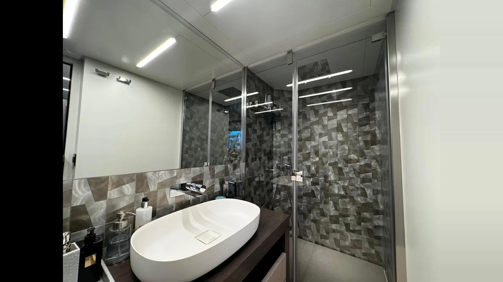 a bathroom with a glass shower aboard 2023 80' PERSHING 8X Yacht for Sale