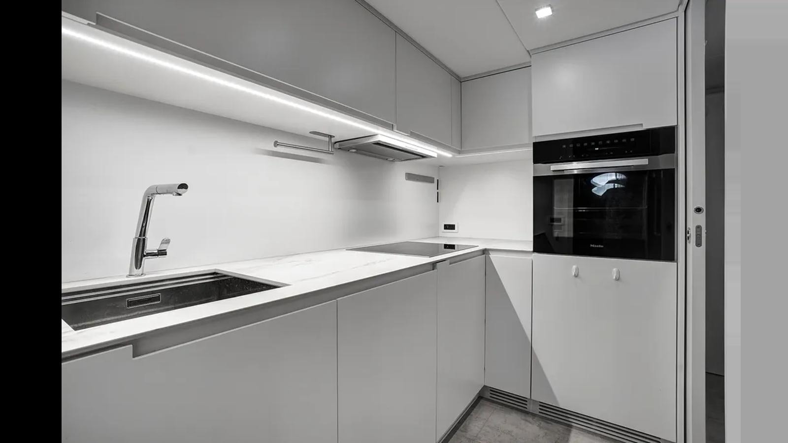 a kitchen with white cabinets aboard 2023 80' PERSHING 8X Yacht for Sale