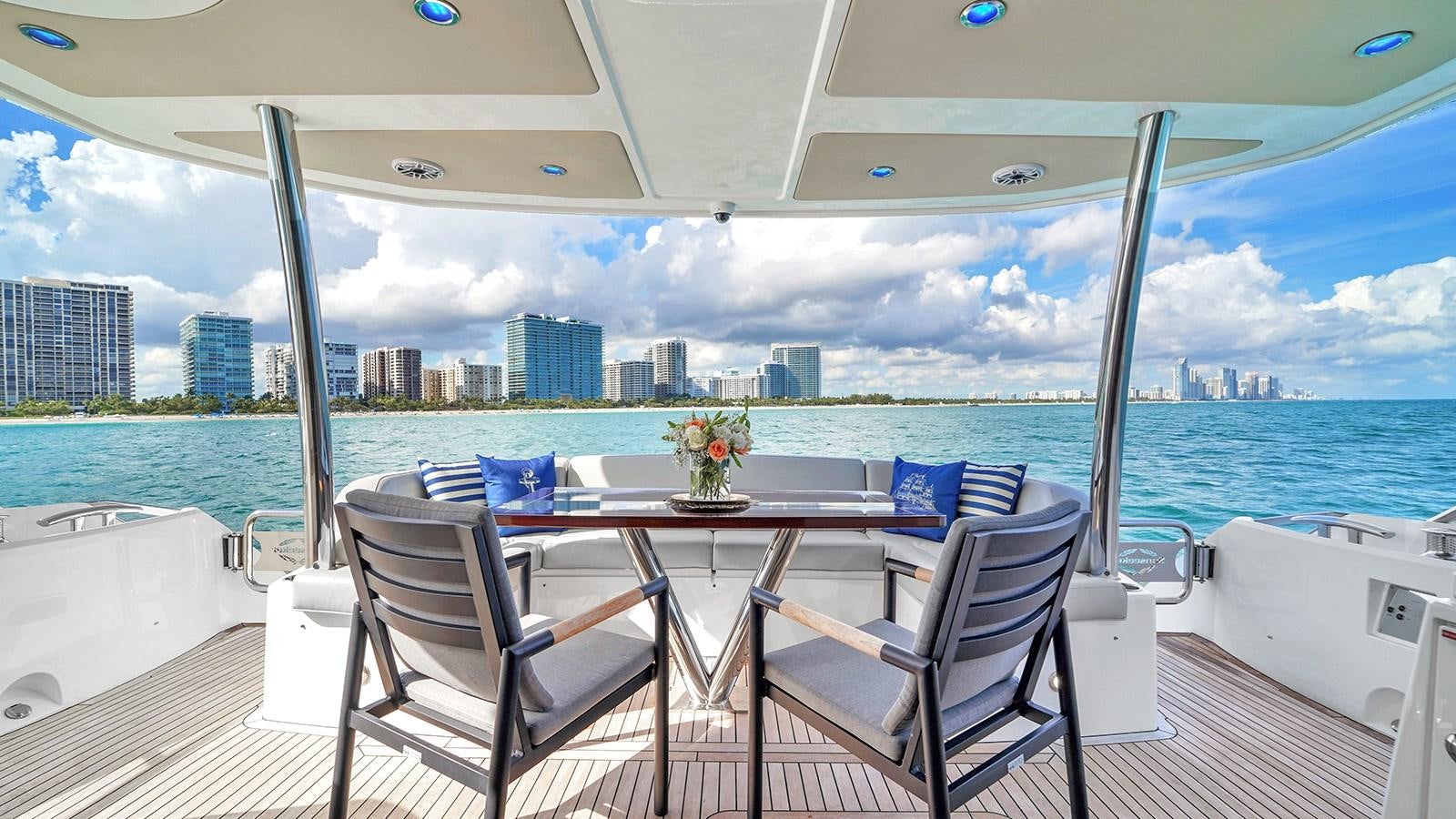 a table and chairs on a deck overlooking a city aboard M4 Yacht for Sale