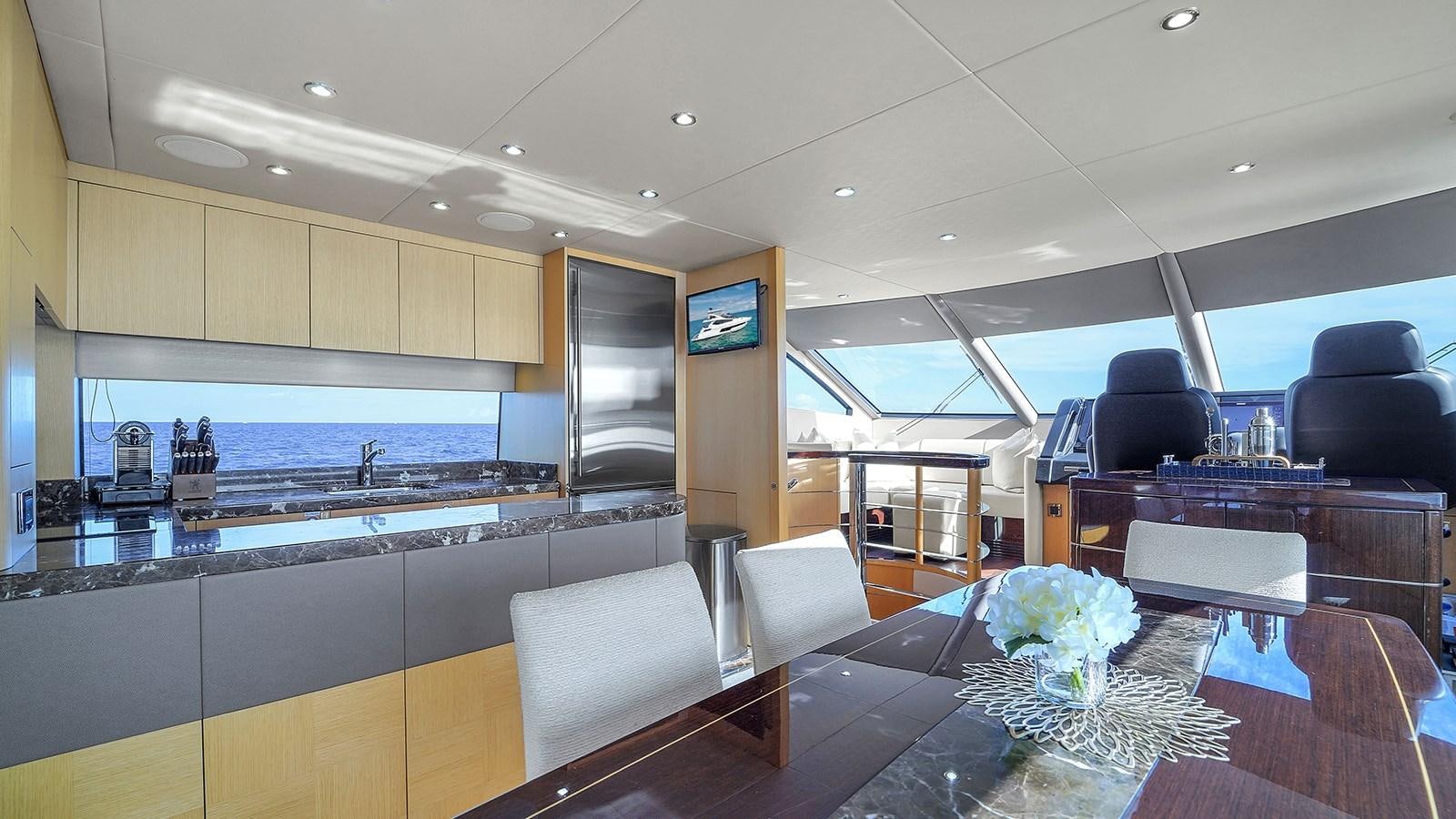 a large kitchen with a bar and bar seating aboard M4 Yacht for Sale