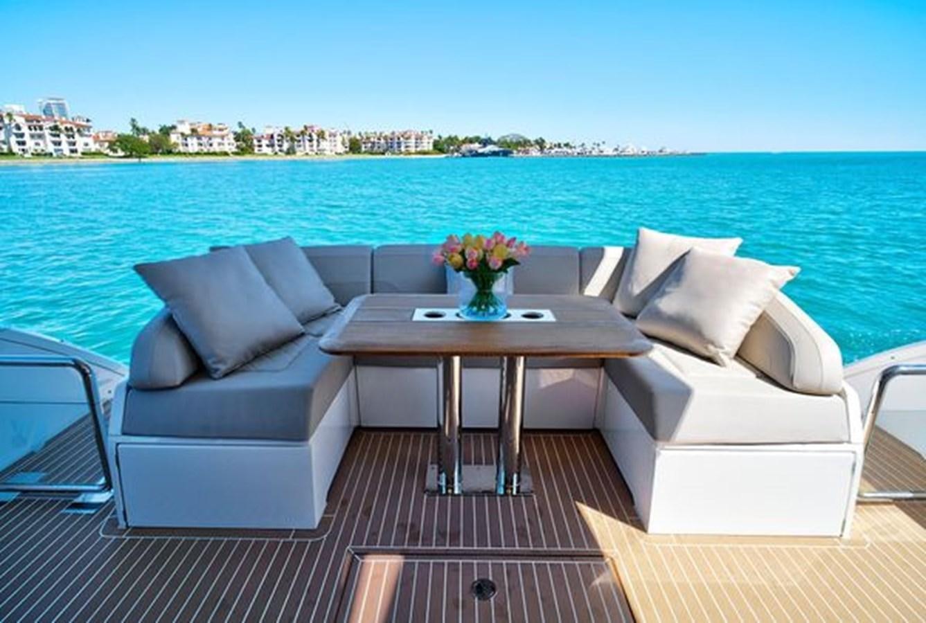 a table and chairs on a deck overlooking a body of water aboard 2021 FAIRLINE SQUADRON 68 Yacht for Sale