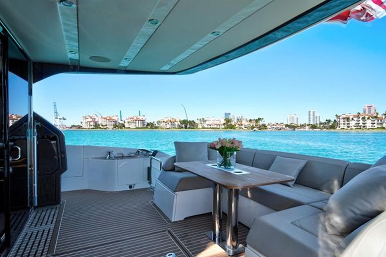 a table and chairs on a deck overlooking a body of water aboard 2021 FAIRLINE SQUADRON 68 Yacht for Sale