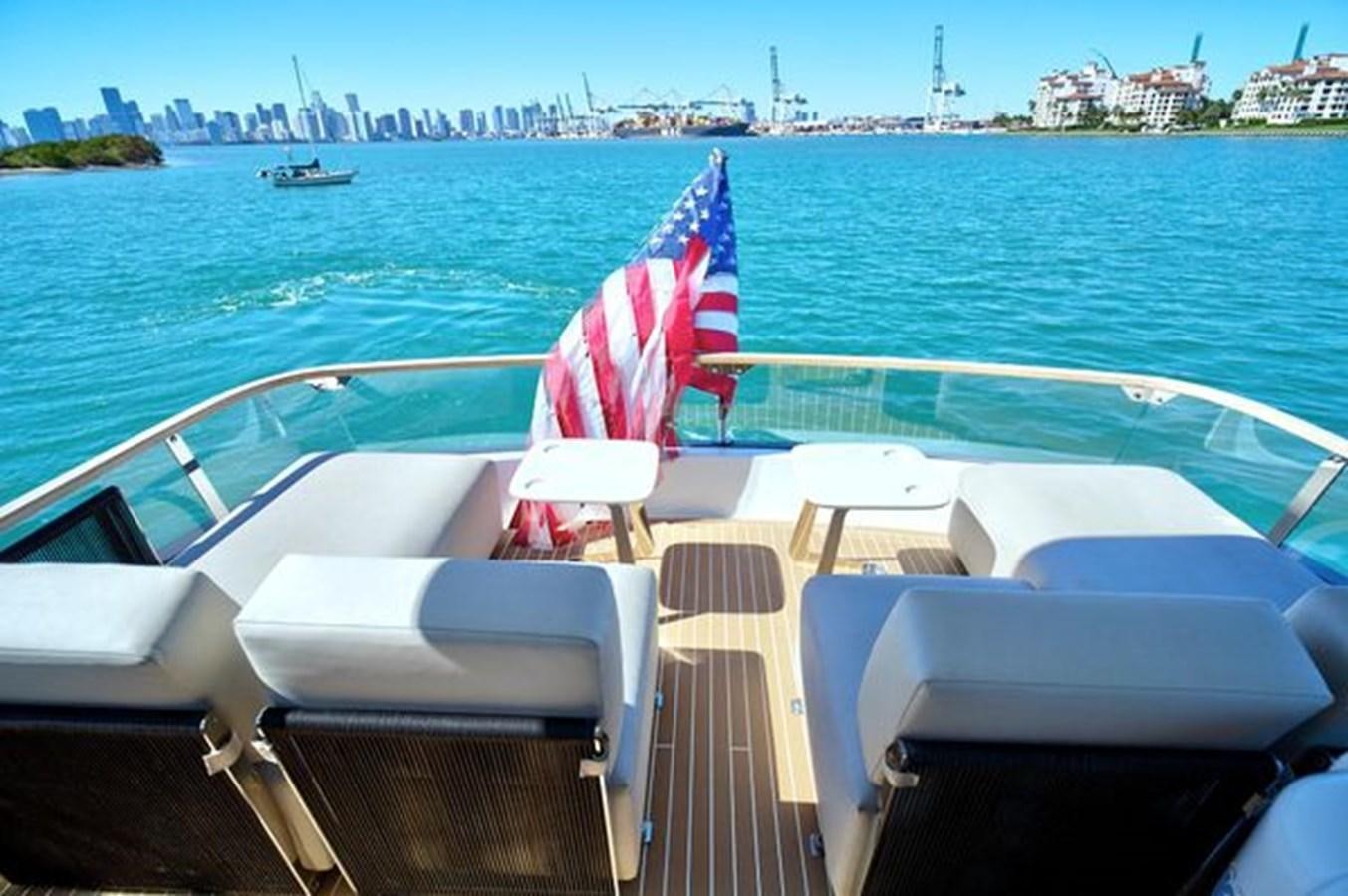 a boat with white chairs and a flag on it aboard 2021 FAIRLINE SQUADRON 68 Yacht for Sale