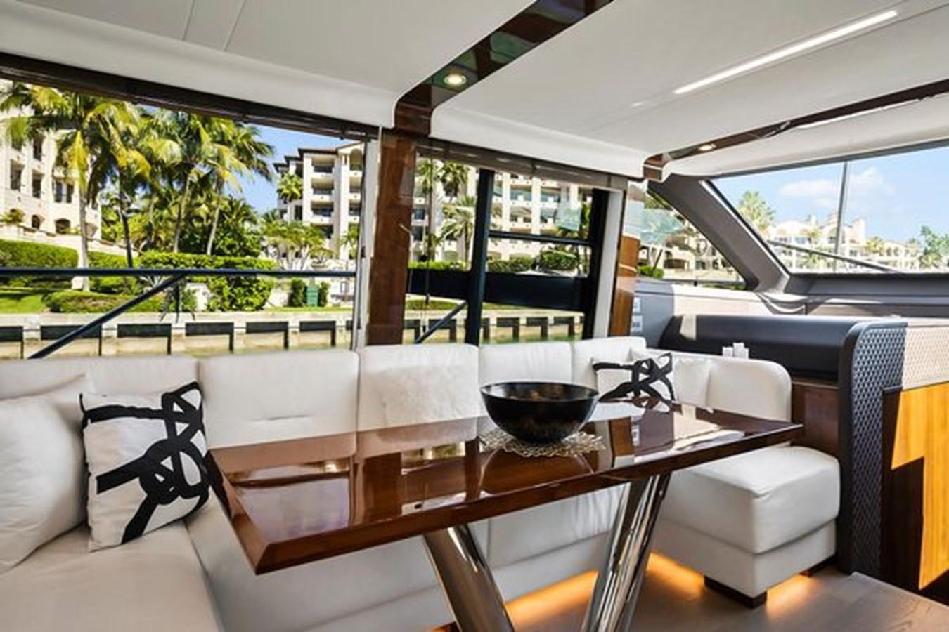 a table with chairs and a glass bowl on it aboard 2021 FAIRLINE SQUADRON 68 Yacht for Sale